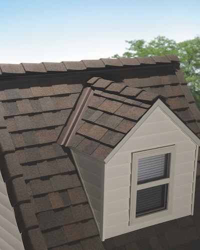 Close-up of dormer window with brown shingle roofing installed by Rooftek